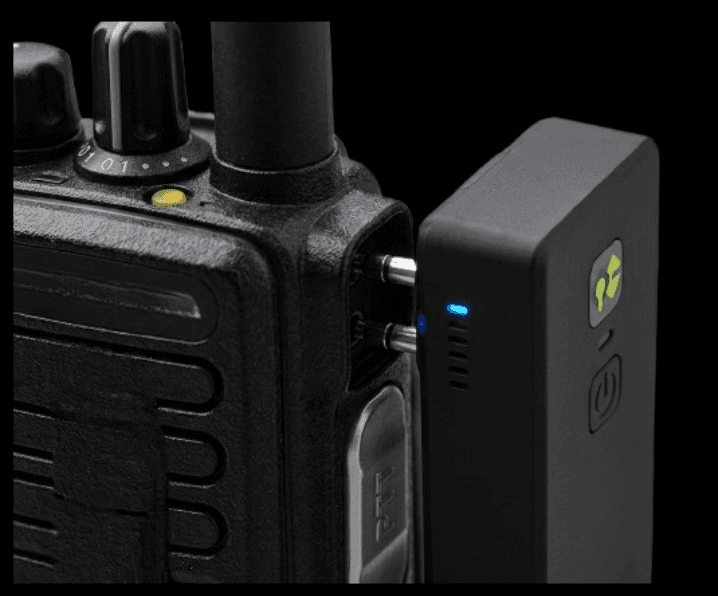 QuickComm bridge dongle connected to a professional handheld radio